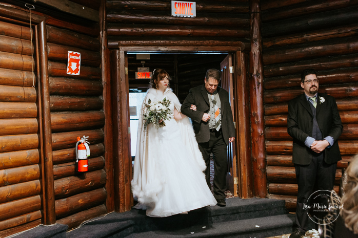 Winter wedding photos in the snow. Indoor ceremony in wooden cabin by the fire place wooden walls harsh light natural light. Bride walking down the aisle with father meeting groom. Mariage féerique hivernal à l'Hôtel Mont-Gabriel. Mariage hiver Laurentides. Photographe mariage Montréal | Lisa-Marie Savard Photographie | Montréal, Québec | www.lisamariesavard.com