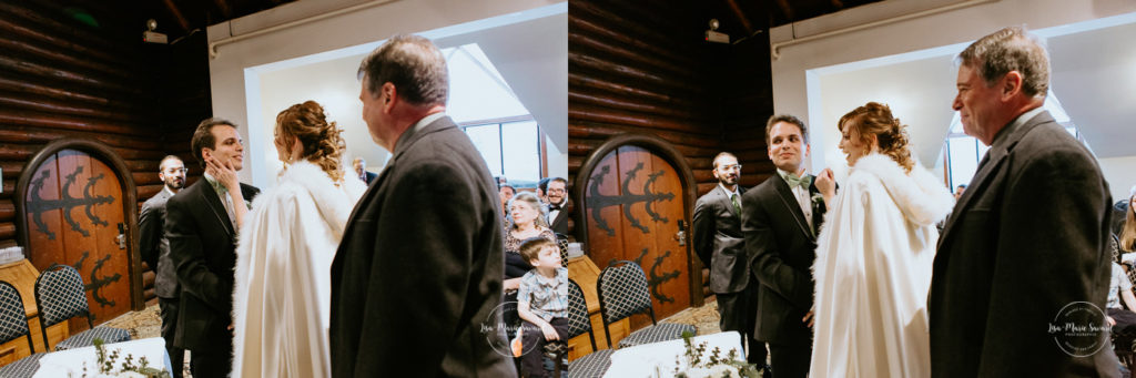 Winter wedding photos in the snow. Indoor ceremony in wooden cabin by the fire place wooden walls harsh light natural light. Bride walking down the aisle with father meeting groom. Mariage féerique hivernal à l'Hôtel Mont-Gabriel. Mariage hiver Laurentides. Photographe mariage Montréal | Lisa-Marie Savard Photographie | Montréal, Québec | www.lisamariesavard.com