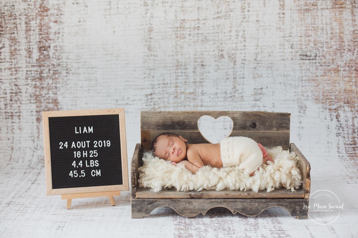 Preemie newborn photos. NICU newborn session. Mixed baby photos. Baby laying on wooden bed with felt letter board.