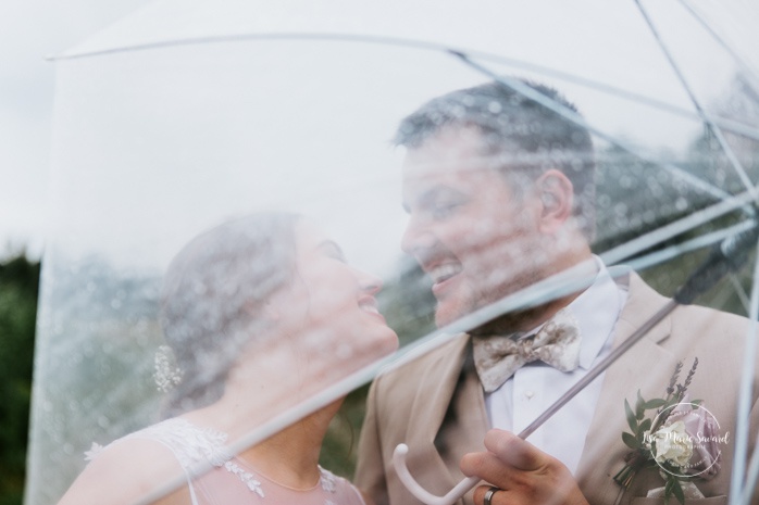 Rainy wedding photos under clear umbrellas. Photos de mariage rustique à la campagne. Photographe de mariage à Trois-Rivières