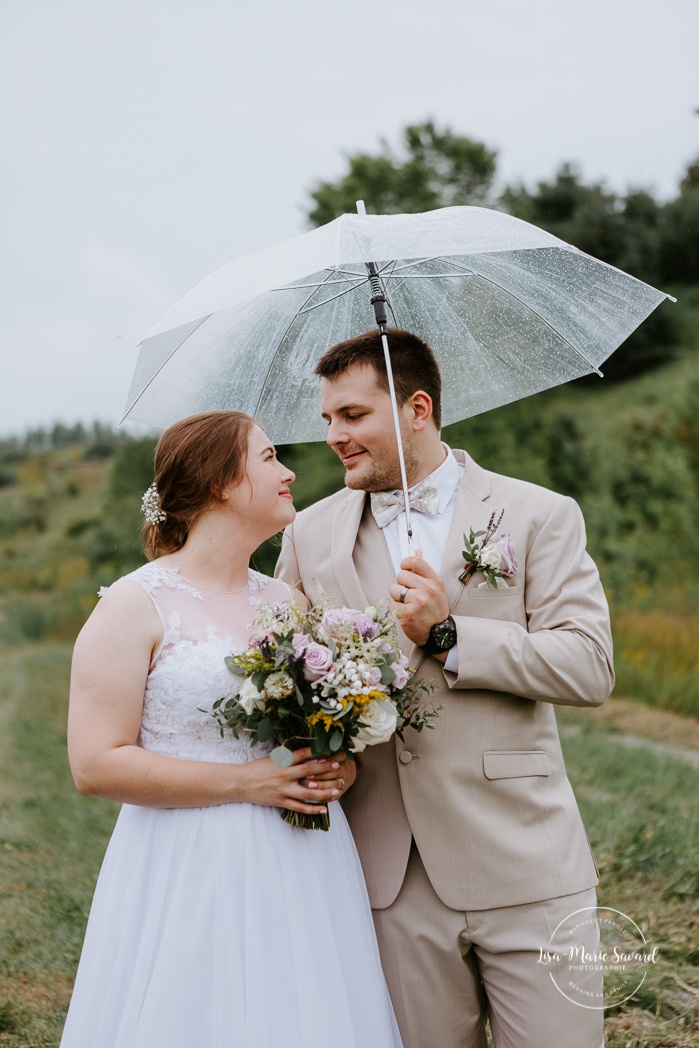 Rainy wedding photos under clear umbrellas. Photos de mariage rustique à la campagne. Photographe de mariage à Trois-Rivières