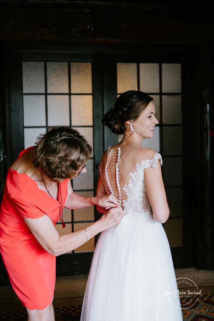 Mother buttoning the bride's dress. Mariage en Outaouais. Fairmont Le Château Montebello wedding. Ottawa photographer.