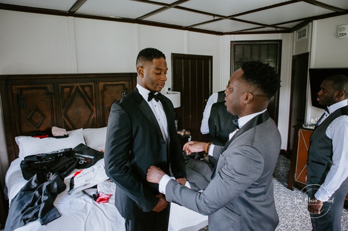 African American groom getting ready with groomsmen in hotel room. Mariage en Outaouais. Outaouais wedding. Ottawa photographer.