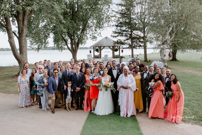 Wedding group picture with guests after ceremony. Mariage en Outaouais. Fairmont Le Château Montebello outdoor wedding. Ottawa photographer.