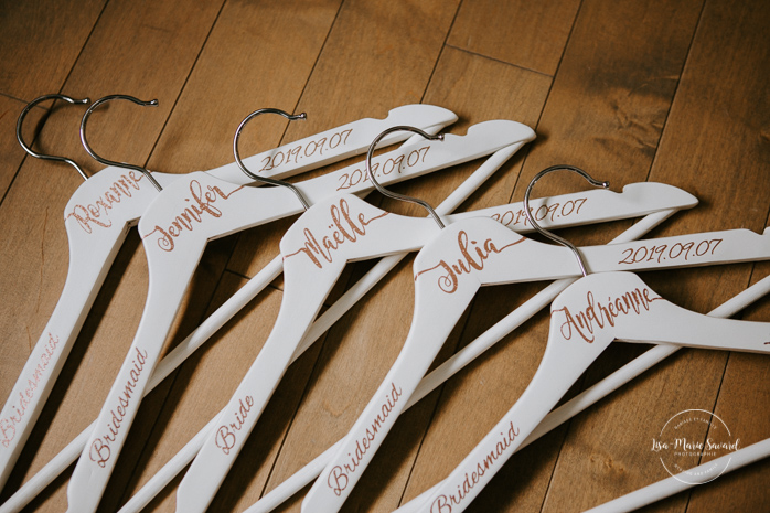 Customized dress hanger with bride and bridesmaids name. Asian bride getting ready with four bridesmaids. Mariage à l'Orée des Champs en automne. Orée des Champs Saint-Nazaire Saguenay-Lac-Saint-Jean. Photographe de mariage Saguenay.