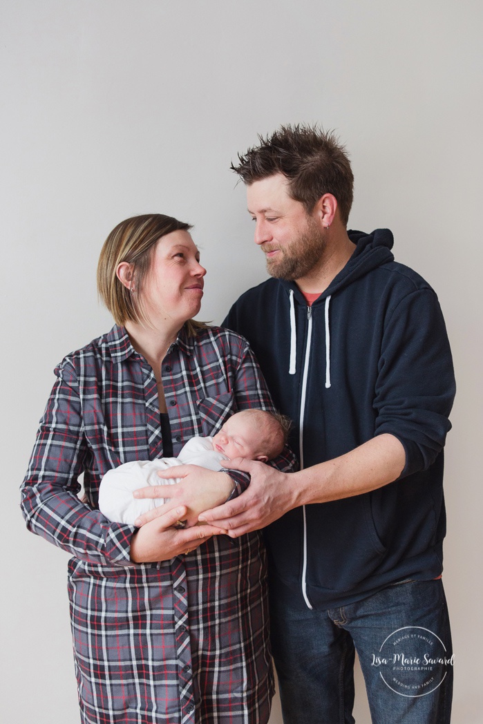 Mom and dad holding newborn baby. Parents holding baby. Simple newborn photos. Minimalist newborn photos. Photographe de bébé à Montréal. Montreal baby photographer