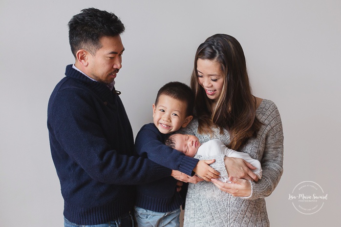 Newborn family photos. Parents holding baby with big brother. Asian girl newborn photos. Photoshoot de nouveau-né à Montréal. Montreal newborn photoshoot