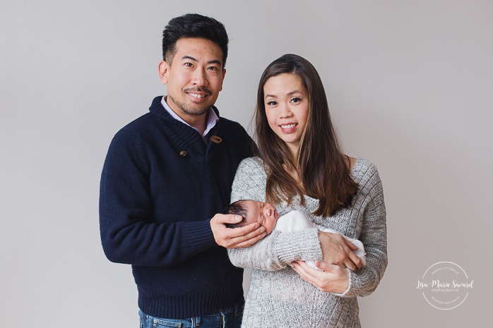 Newborn family photos. Parents holding baby in their arms. Asian girl newborn photos. Photoshoot de nouveau-né à Montréal. Montreal newborn photoshoot