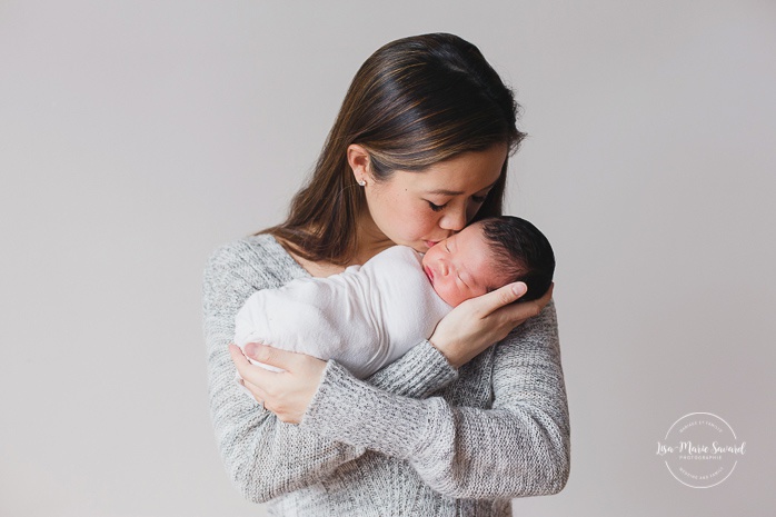 Newborn family photos. Mom holding and kissing baby girl. Asian girl newborn photos. Photoshoot de nouveau-né à Montréal. Montreal newborn photoshoot