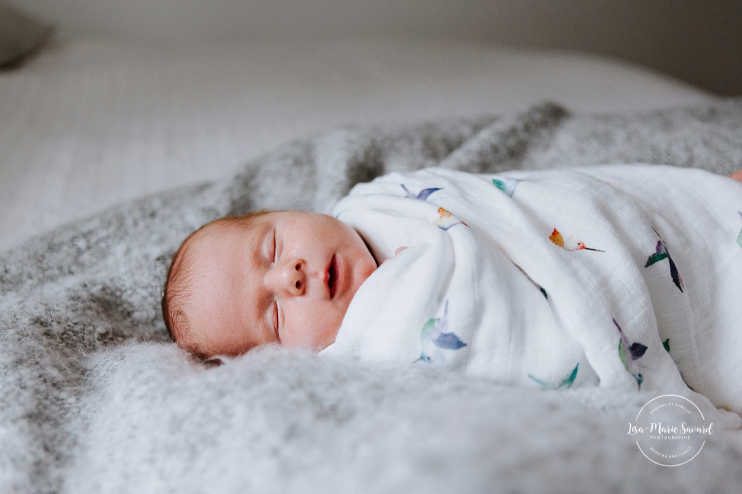 In-home lifestyle newborn session. Newborn photos in nursery. Baby boy wrapped in blanket on bed. Séance nouveau-né sur la Rive-Nord de Montréal. Montreal North Shore newborn photoshoot.