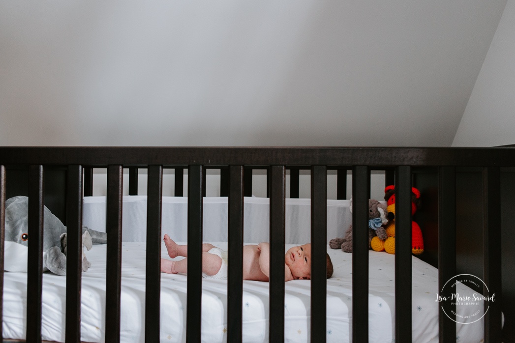 In-home lifestyle newborn session. Newborn photos in nursery. Baby inside crib. Séance nouveau-né sur la Rive-Nord de Montréal. Montreal North Shore newborn photoshoot.