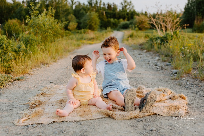 Family photos in a field. Golden hour family photos. Brother and sister reading book. Toddler boy and baby sister. Sibling photos. Séance photo dans un champ sauvage. Photographe de famille au Saguenay-Lac-Saint-Jean. Saguenay family photographer.