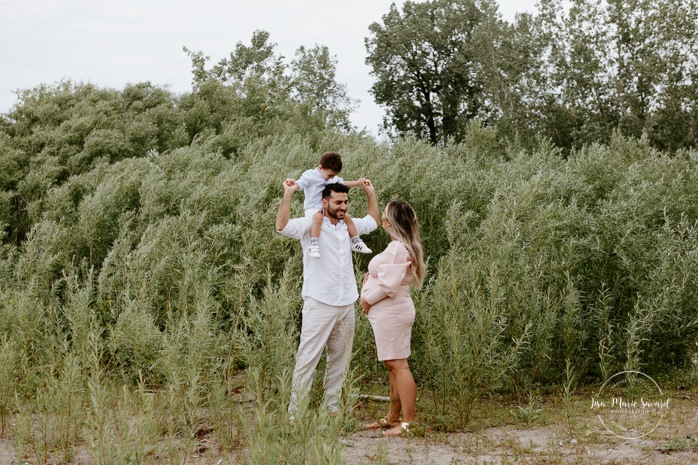 Maternity photos next to river. Maternity session by waterfront. Beach grass. Maternity photos with toddler. Maternity session little boy. Séance maternité à la Berge des Baigneurs à Laval. Photographe de maternité à Laval. Laval maternity photographer.