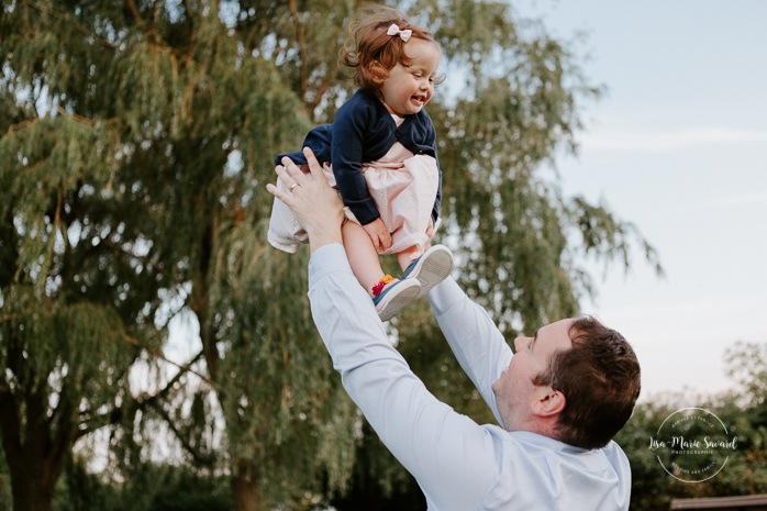 Dad playing with daughter. Father and daughter photos. Outdoor family session. Outdoor family photos. Family of four photos. Photographe à Dorval. Photographe de famille à Montréal. Montreal West Island family photos. Montreal family photographer.