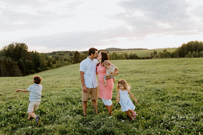 Children running around parents. Dairy farm photos with cows. Farm photo session. Family photos with cows. Countryside family photos. Photos de famille à la campagne. Photos de famille dans un champ. Photographe de famille à Montréal. Montreal family photographer.