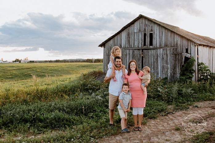 Family photos in front of old barn. Barn family photos. Dairy farm photos with cows. Farm photo session. Family photos with cows. Countryside family photos. Photos de famille à la campagne. Photos de famille dans un champ. Photographe de famille à Montréal. Montreal family photographer.