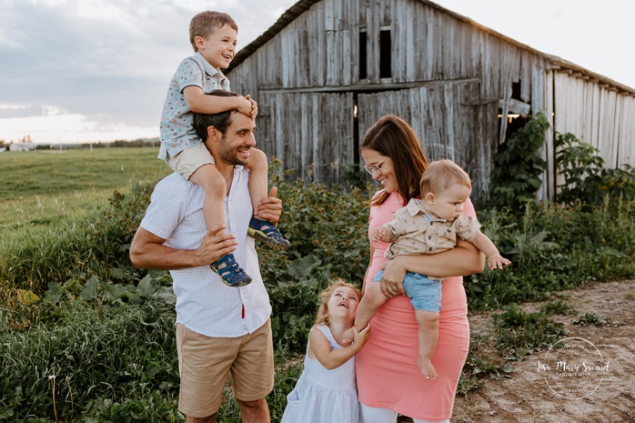 Family photos in front of old barn. Barn family photos. Dairy farm photos with cows. Farm photo session. Family photos with cows. Countryside family photos. Photos de famille à la campagne. Photos de famille dans un champ. Photographe de famille à Montréal. Montreal family photographer.