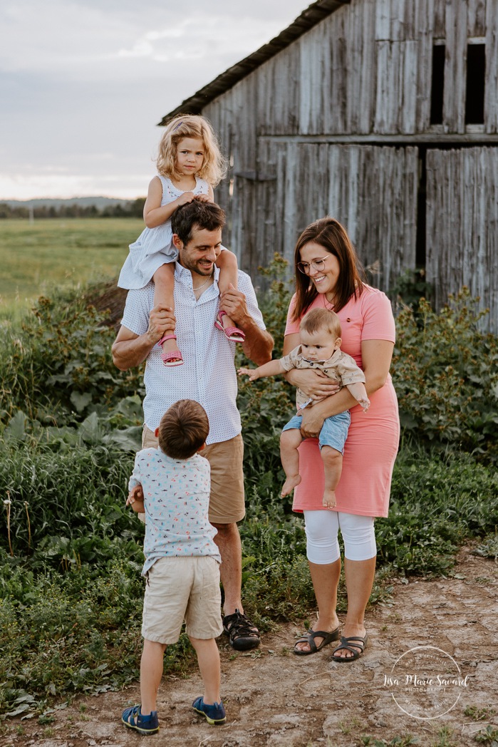 Family photos in front of old barn. Barn family photos. Dairy farm photos with cows. Farm photo session. Family photos with cows. Countryside family photos. Photos de famille à la campagne. Photos de famille dans un champ. Photographe de famille à Montréal. Montreal family photographer.