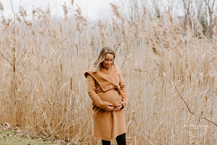 Winter maternity photos without snow. Maternity photos in front of pampas. Maternity photos next to lake. Mom holding belly. Photos de maternité dans le Sud-Ouest. Photographe de maternité à Ville-Émard. Montreal Southwest maternity photos.