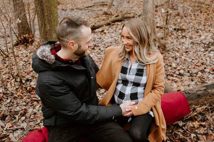 Winter maternity photos without snow. Maternity session in forest. Couple sitting on fallen tree. Photographe à Ville-Émard. Montreal Southwest maternity photos.