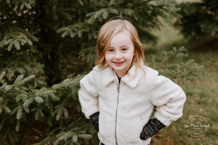 Young girl in front of pine tree. Winter maternity photos without snow. Maternity photos with child. Maternity photos with sibling. Photos de maternité dans le Sud-Ouest. Photographe de maternité à Ville-Émard. Montreal Southwest maternity photos.