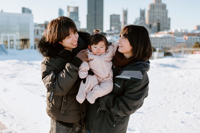 Winter family session. Family photos in the snow. Asian family photos. Family photos cityscape. Skyline family photos. Séance photo dans le Vieux-Port de Montréal. Photos de famille à Montréal. Grand Quai de Montréal. Promenade d'Iberville. Old Port of Montreal photo session. Montreal family photos.