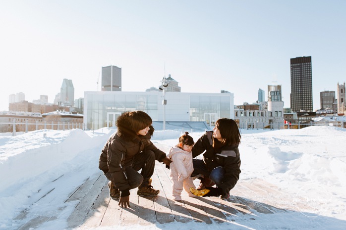 Winter family session. Family photos in the snow. Asian family photos. Family photos cityscape. Skyline family photos. Séance photo dans le Vieux-Port de Montréal. Photos de famille à Montréal. Grand Quai de Montréal. Promenade d'Iberville. Old Port of Montreal photo session. Montreal family photos.