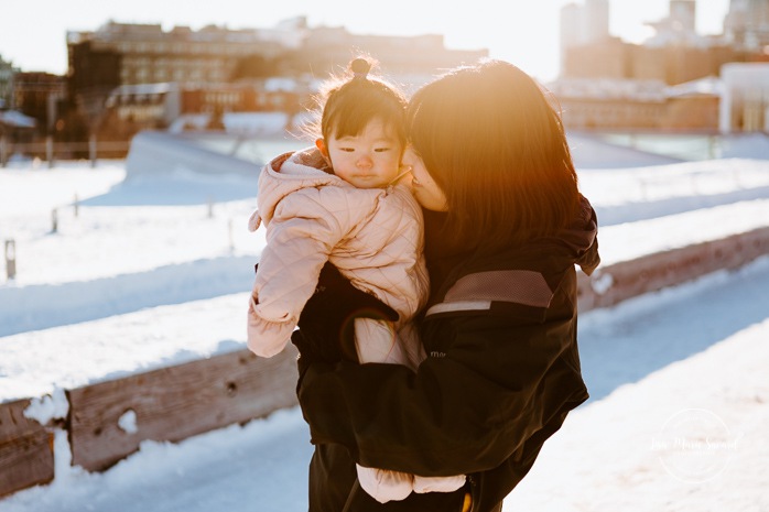 Winter family session. Family photos in the snow. Asian family photos. Family photos cityscape. Skyline family photos. Séance photo dans le Vieux-Port de Montréal. Photos de famille à Montréal. Grand Quai de Montréal. Promenade d'Iberville. Old Port of Montreal photo session. Montreal family photos.