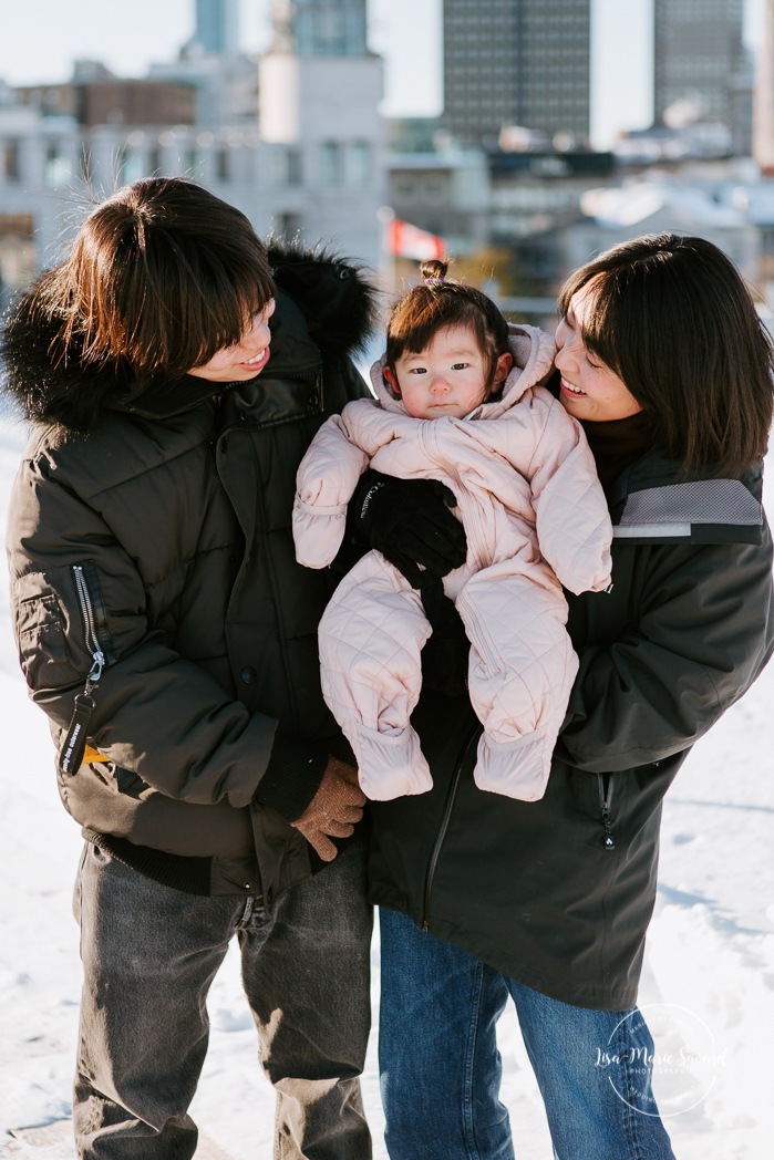 Winter family session. Family photos in the snow. Asian family photos. Family photos cityscape. Skyline family photos. Photos de famille à Montréal. Grand Quai de Montréal. Promenade d'Iberville. Montreal family photos.