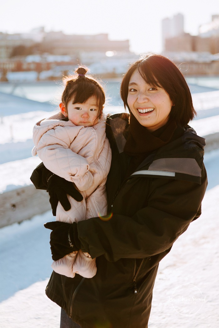 Winter family session. Family photos in the snow. Asian family photos. Family photos cityscape. Skyline family photos. Séance photo dans le Vieux-Port de Montréal. Photos de famille à Montréal. Grand Quai de Montréal. Promenade d'Iberville. Old Port of Montreal photo session. Montreal family photos.