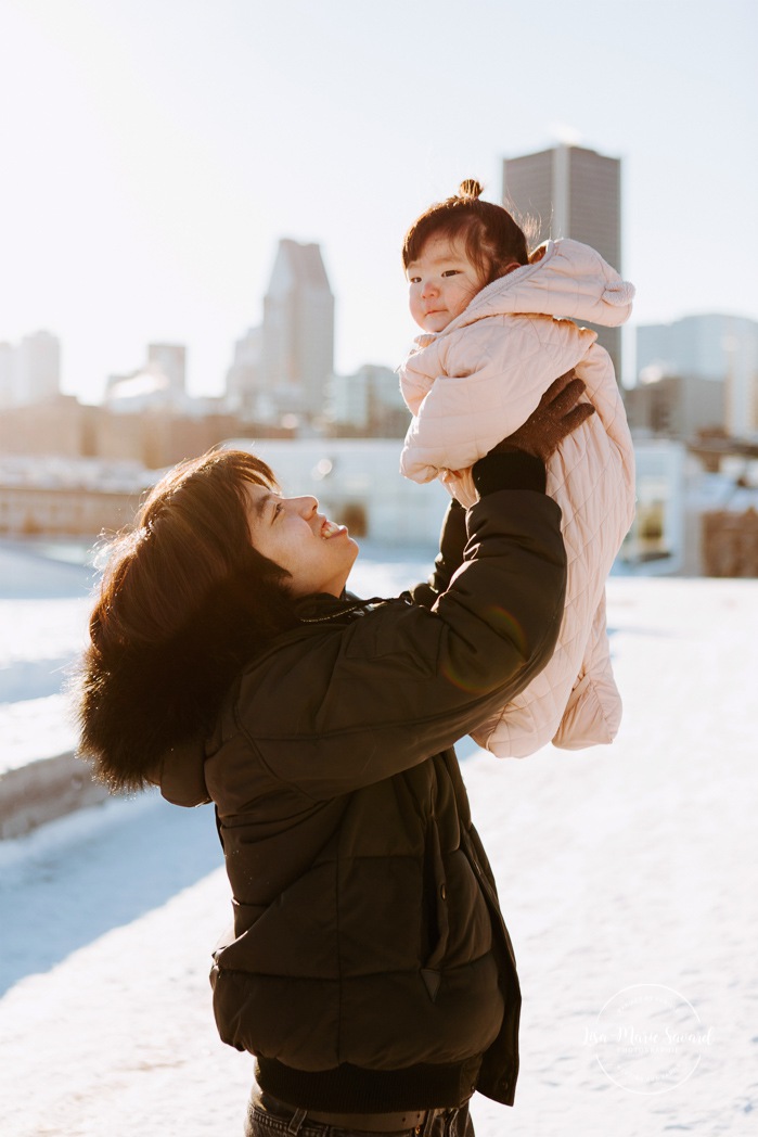 Winter family session. Family photos in the snow. Asian family photos. Family photos cityscape. Skyline family photos. Séance photo dans le Vieux-Port de Montréal. Photos de famille à Montréal. Grand Quai de Montréal. Promenade d'Iberville. Old Port of Montreal photo session. Montreal family photos.