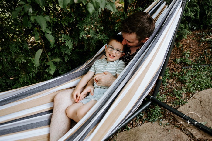 Dad and toddler boy playing on hammock. In-home family session. Lifestyle family photos. Back yard family photos. Family photos with two boys. Séance photo à Montréal. Séance familiale à Montréal. Town of Mount Royal family photographer
