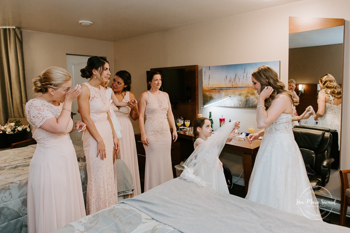 Bridesmaids first look with bride. Bride getting ready with bridesmaids in hotel room. Pandemic wedding. COVID-19 micro wedding. Mariage en Beauce durant la pandémie. Photographe de mariage Beauce. Motel Invitation Sainte-Marie.