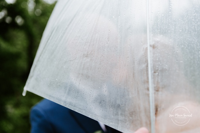 Rainy wedding photos. Wedding photos with clear umbrellas. Mariage en Beauce durant la pandémie. Photographe de mariage Beauce. La Bouche Bée Saint-Sylvestre.