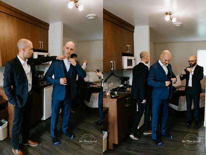 Groom getting ready with groomsmen in hotel room. Mariage en Beauce durant la pandémie. Photographe de mariage Beauce. Motel Invitation Sainte-Marie.