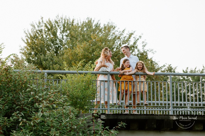 Outdoor family session with three children. Family photos on bridge. Family photos with three girls. Photos de famille à l'Îlot John-Gallagher à Verdun. Photographe à Verdun. Verdun family photos by the riverbanks. Verdun photographer.