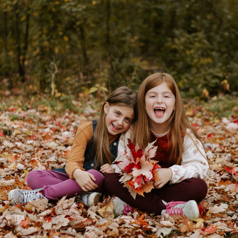 Fall family photos. Fall family session. Family photos with school aged girls. Siblings playing with leaves. Mini séance d'automne à Montréal 2021. Photographe de famille à Montréal. Montreal fall mini session 2021. Montreal family photographer.