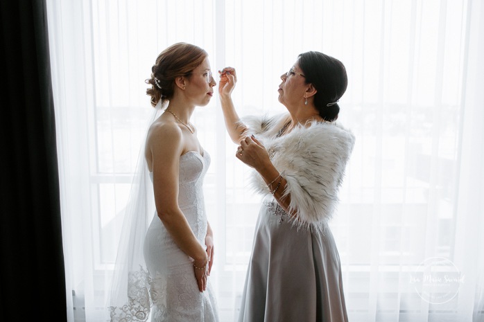Bride getting ready with mother in hotel room. Winter wedding photos. Mariage à Chicoutimi en hiver. Mariage Hôtel Chicoutimi. Photographe de mariage au Saguenay.