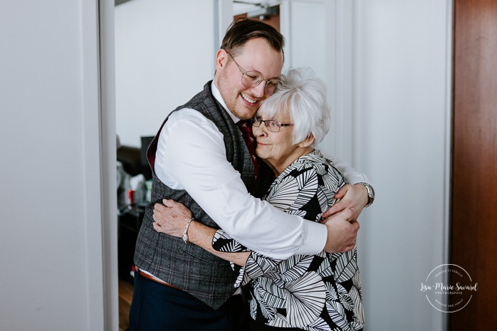 Groom hugging grandmother. Winter wedding photos. Mariage à Chicoutimi en hiver. Mariage Hôtel Chicoutimi. Photographe de mariage au Saguenay.
