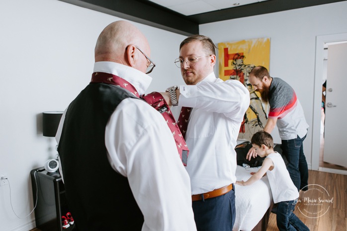 Groom getting ready with groomsmen in hotel room. Winter wedding photos. Mariage à Chicoutimi en hiver. Mariage Hôtel Chicoutimi. Photographe de mariage au Saguenay.