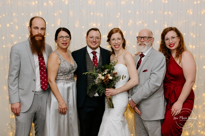 Wedding family photos in front of curtain lights. Intimate wedding reception. Mariage à Chicoutimi en hiver. Photographe de mariage au Saguenay. Mariage Hôtel Chicoutimi