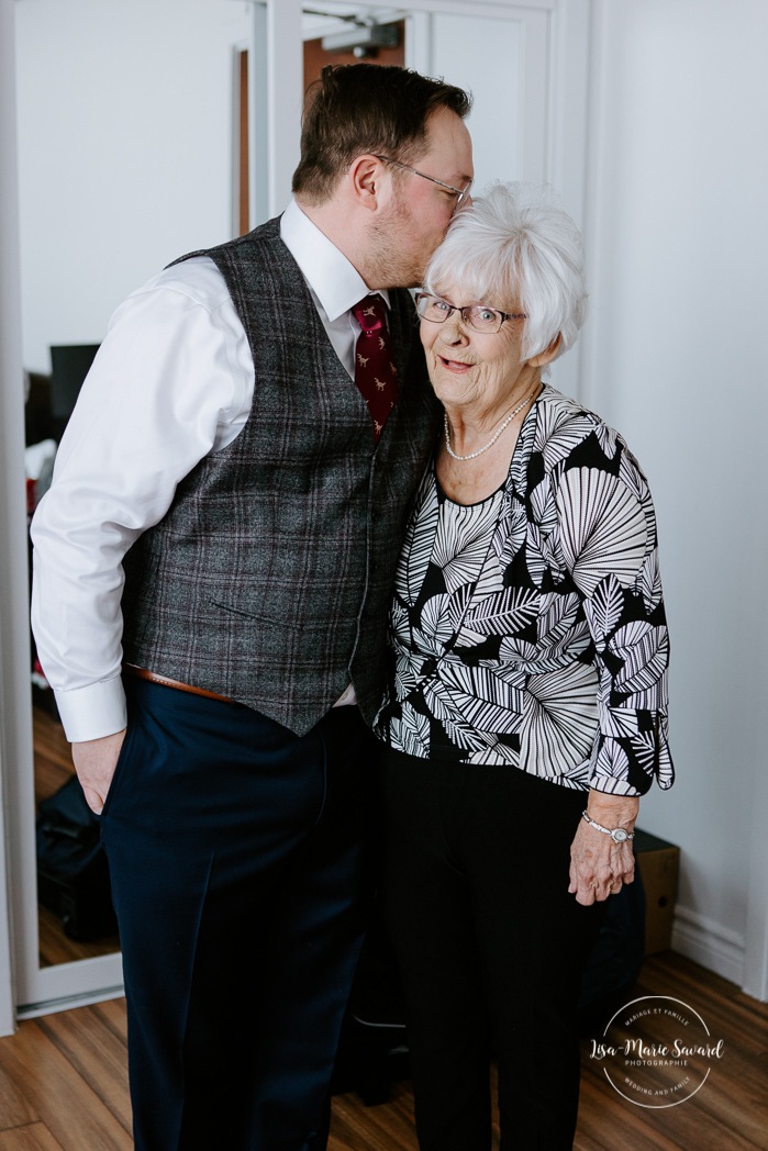 Groom hugging grandmother. Winter wedding photos. Mariage à Chicoutimi en hiver. Mariage Hôtel Chicoutimi. Photographe de mariage au Saguenay.