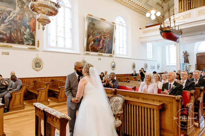 Bride and groom first kiss. Wedding ceremony in patrimonial church. Mariage église Notre-Dame-des-Victoires. Mariage dans le Vieux-Québec. Photographe mariage Québec. Old Quebec wedding photos.