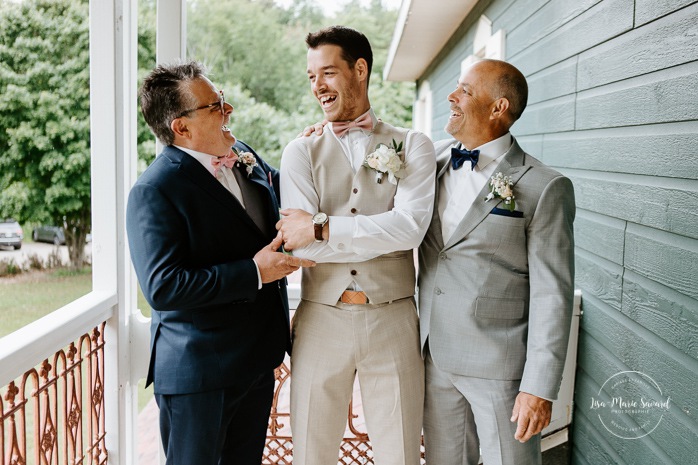 Groom laughing with father and father in law. Photographe de mariage en Mauricie. Mariage Le Baluchon Éco-Villégiature. 
