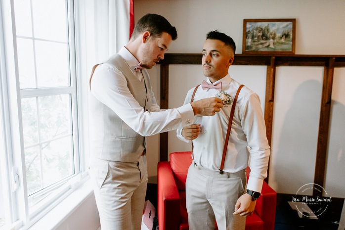 Groom getting ready with groomsmen in hotel room. Photographe de mariage en Mauricie. Mariage Le Baluchon Éco-Villégiature. 