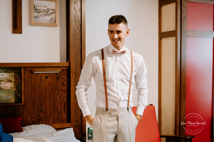 Groom getting ready with groomsmen in hotel room. Photographe de mariage en Mauricie. Mariage Le Baluchon Éco-Villégiature. 