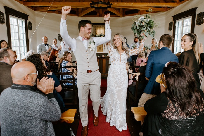 Bride and groom exiting ceremony. Wedding ceremony in intimate chapel. Photographe de mariage en Mauricie. Mariage Le Baluchon Éco-Villégiature. 