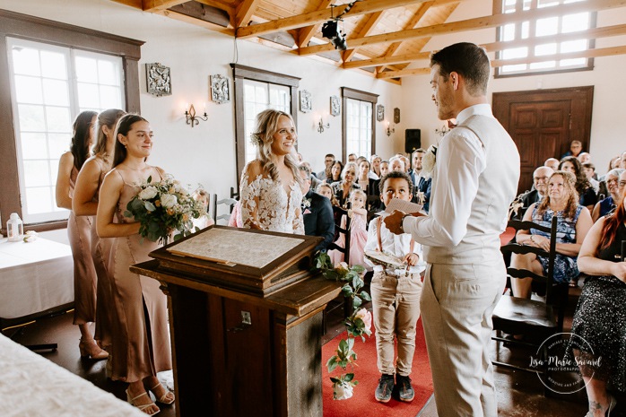 Groom reading emotional vows. Wedding ceremony in intimate chapel. Photographe de mariage en Mauricie. Mariage Le Baluchon Éco-Villégiature. 