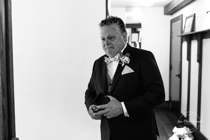 Father of the bride crying when seeing her. Bride getting ready with bridesmaids in hotel room. Photographe de mariage en Mauricie. Mariage Le Baluchon Éco-Villégiature. 