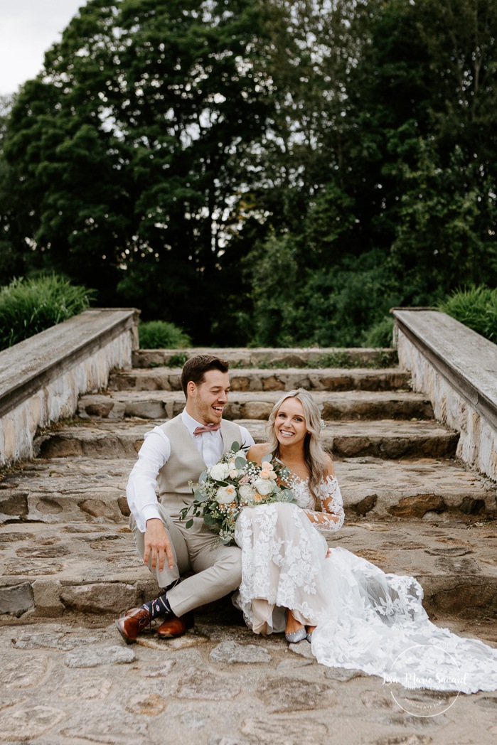 Romantic wedding photos. Bride and groom sitting on stone steps. Photographe de mariage en Mauricie. Mariage Le Baluchon Éco-Villégiature. 